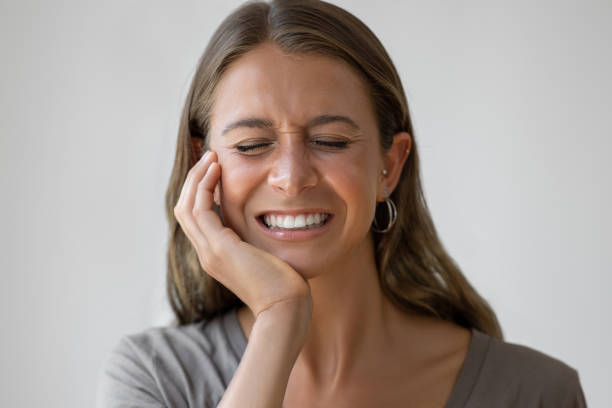 Mujer con dolor mandibular por bruxismo apretando los dientes