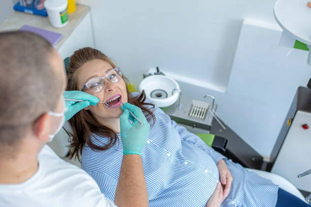Mujer embarazada siendo atendida en consulta dental durante tratamiento de ortodoncia invisible